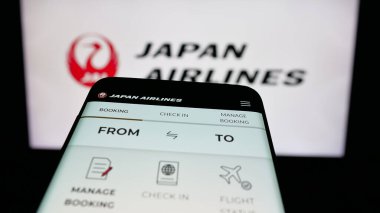 Stuttgart, Almanya - 04-25-2025: Havayolu şirketi Japan Airlines Co. Ltd. (JAL) 'in web sayfası logonun önünde. Telefon ekranının sol üst kısmına odaklan.