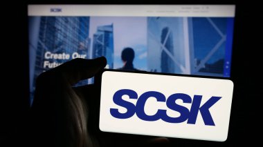 Stuttgart, Almanya - 04-25-2025: Japon bilişim şirketi SCSK Corporation 'ın logosunun bulunduğu cep telefonu web sayfası önünde ekranda. Telefon ekranına odaklan.