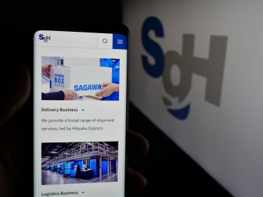 Stuttgart, Almanya - 04-26-2025: Lojistik şirketi SG Holding Co. Ltd. nin web sayfası olan cep telefonu logonun önünde ekranda. Telefon ekranının merkezine odaklan.