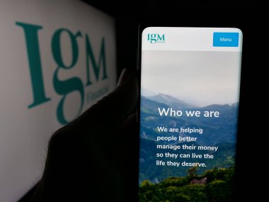 Stuttgart, Almanya - 04-26-2025: Kanadalı finans şirketi IGM Financial Inc. 'in web sitesi ile akıllı telefon sahibi kişi logonun önünde ekranda. Telefon ekranının merkezine odaklan.
