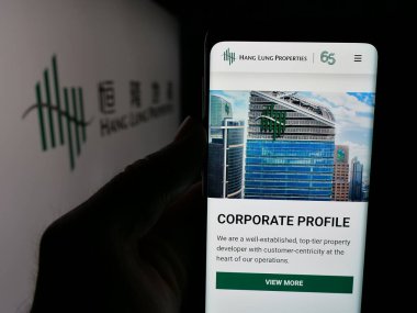 Stuttgart, Almanya - 04-26-2025: Çinli şirket Hang Lung Properties Limited 'in web sitesiyle akıllı telefon sahibi kişi logonun önünde ekranda görülüyor. Telefon ekranının merkezine odaklan.