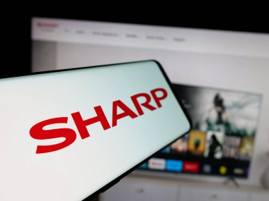 Stuttgart, Almanya - 04-26-2025: İnternet sitesinin önündeki ekranda elektronik şirketi Sharp Corporation 'ın logosu olan akıllı telefon. Telefon ekranının merkez soluna odaklan.