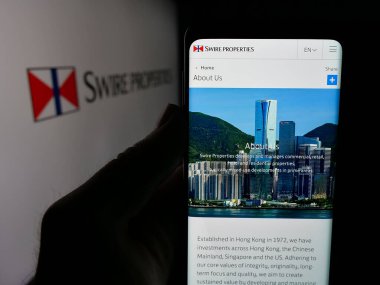 Stuttgart, Almanya - 04-26-2025: Emlak şirketi Swire Properties Limited 'in web sayfası olan cep telefonu logosu önünde ekranda. Telefon ekranının merkezine odaklan.