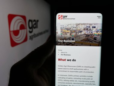 Stuttgart, Almanya - 04-26-2025: Palmiye yağı şirketi Golden Agri-Resources 'un (GAR) web sayfası logonun önünde bulunan kişi. Telefon ekranının merkezine odaklan.