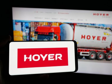 Stuttgart, Almanya - 04-26-2025: Lojistik şirketi Wilhelm Hoyer B.V. Co. KG 'nin logosuna sahip akıllı telefon sahibi kişi web sitesinin önünde ekranda. Telefon ekranına odaklan.