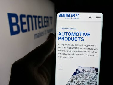 Stuttgart, Almanya - 04-26-2025: Otomotiv şirketi Benteler International AG 'nin web sitesi ile akıllı telefon sahibi kişi logonun önünde ekranda. Telefon ekranının merkezine odaklan.