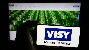 Stuttgart, Almanya - 04-26-2025: Cep telefonunda ambalaj şirketi Visy Industries 'in logosu olan kişi web sayfasının önünde ekranda. Telefon ekranına odaklan.
