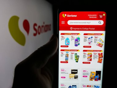 Stuttgart, Almanya - 04-26-2025: Organizacion Soriana S.A.B. şirketinin web sayfası ile cep telefonu tutan kişi De CV ekranda logonun önünde. Telefon ekranının merkezine odaklan.
