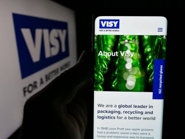 Stuttgart, Almanya - 04-26-2025: Cep telefonunda ambalaj şirketi Visy Industries 'in web sayfası bulunan kişi logonun önünde ekranda. Telefon ekranının merkezine odaklan.