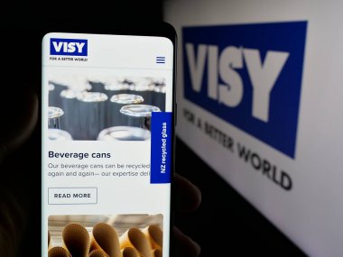 Stuttgart, Almanya - 04-26-2025: Ambalaj şirketi Visy Industries 'in web sitesi ile logo önünde akıllı telefon tutan kişi. Telefon ekranının merkezine odaklan.