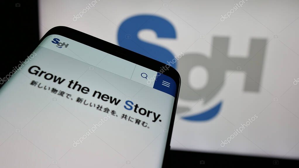 Stuttgart, Germany - 04-26-2025: Mobile phone with webpage of logistics company SG Holdings Co. Ltd. on screen in front of logo. Focus on top-left of phone display.