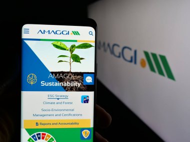 Stuttgart, Almanya - 04-28-2025: Brezilyalı tarım şirketi Amaggi Group 'un web sayfası olan cep telefonu logosu önünde ekranda. Telefon ekranının merkezine odaklan.