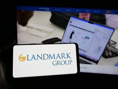 Stuttgart, Almanya - 04-28-2025: İnternet sitesinin önünde üzerinde BAE holding şirketi Landmark Group 'un logosu bulunan akıllı telefon sahibi kişi. Telefon ekranına odaklan.