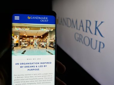 Stuttgart, Almanya - 04-28-2025: BAE holding şirketi Landmark Group 'un web sayfasını elinde tutan kişi logonun önünde ekranda. Telefon ekranının merkezine odaklan.