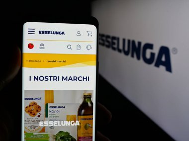Stuttgart, Almanya - 04-28-2025: İtalyan perakende şirketi Esselunga S.P.A. 'nın web sitesi ile akıllı telefon sahibi kişi logonun önünde ekranda. Telefon ekranının merkezine odaklan.