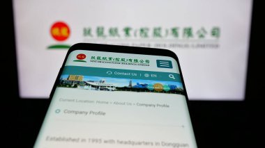 Stuttgart, Almanya - 05-02-2025: Dokuz Ejderha Kağıt (Holding) şirketinin web sayfası bulunan cep telefonu logonun önünde ekranda. Telefon ekranının sol üst kısmına odaklan.