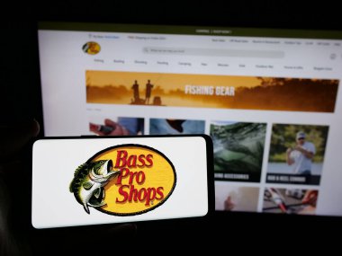 Stuttgart, Almanya - 05-02-2025: ABD 'li Bass Pro Shops (BPS Direct LLC) şirketinin logosuna sahip kişi web sitesinin önünde ekranda. Telefon ekranına odaklan.