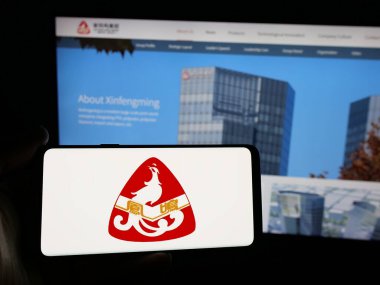 Stuttgart, Almanya - 05-02-2025: Çinli şirket Xin Feng Ming Group Co., Ltd. nin logosunu taşıyan kişi web sitesinin önünde ekranda. Telefon ekranına odaklan.