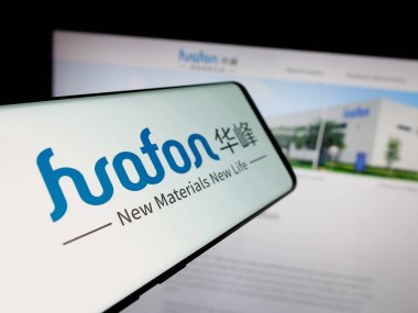 Stuttgart, Almanya - 05-02-2025: Çinli kimya şirketi Huafon Group 'un logosunu içeren akıllı telefon web sitesinin önünde ekranda. Telefon ekranının merkez soluna odaklan.
