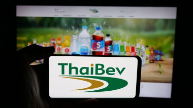 Stuttgart, Almanya - 05-02-2025: İnternet sayfası önünde Thai Beverage plc (ThaiBev) şirketinin logosuna sahip cep telefonu sahibi kişi. Telefon ekranına odaklan.