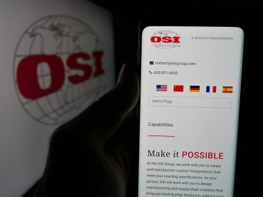 Stuttgart, Almanya - 05-02-2025: ABD 'li et işleme şirketi OSI Group LLC' nin web sitesi ile akıllı telefon sahibi kişi logo önünde ekranda. Telefon ekranının merkezine odaklan.
