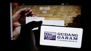Stuttgart, Almanya - 05-02-2025: Endonezyalı tütün şirketi Gudang Garam 'ın logosunun bulunduğu cep telefonu web sayfası önünde ekranda. Telefon ekranına odaklan.