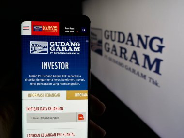 Stuttgart, Almanya - 05-02-2025: Endonezyalı tütün şirketi Gudang Garam 'ın web sitesi ile akıllı telefon taşıyan kişi logonun önünde ekranda. Telefon ekranının merkezine odaklan.