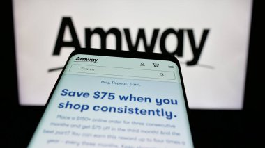 Stuttgart, Almanya - 05-02-2025: ABD 'li çok katlı pazarlama şirketi Amway Corp' un web sayfalı cep telefonu logonun önünde ekranda. Telefon ekranının sol üst kısmına odaklan.