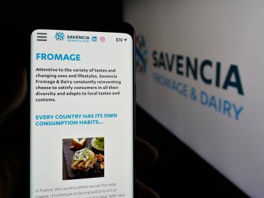Stuttgart, Almanya - 05-03-2025: Fransız süt ürünleri şirketi Savencia S.A. 'nın web sayfası olan cep telefonu logosu önünde ekranda. Telefon ekranının merkezine odaklan.