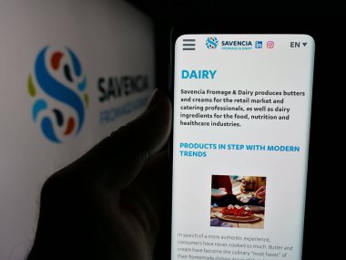Stuttgart, Almanya - 05-03-2025: Fransız süt ürünleri şirketi Savencia S.A. 'nın web sitesi ile akıllı telefonu olan kişi logonun önünde ekranda. Telefon ekranının merkezine odaklan.