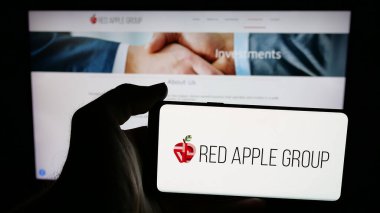 Stuttgart, Almanya - 05-03-2025: ABD 'li emlak şirketi Red Apple Group' un logosunun bulunduğu cep telefonu web sayfası önünde ekranda. Telefon ekranına odaklan.