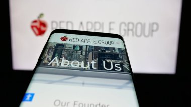 Stuttgart, Almanya - 05-03-2025: ABD 'li emlak şirketi Red Apple Group Inc.' in web sayfası logo önünde ekranda. Telefon ekranının sol üst kısmına odaklan.