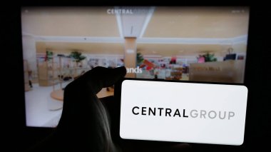 Stuttgart, Almanya - 05-03-2025: İnternet sayfası önünde ekranda Tayland şirketi Central Group 'un logosunun bulunduğu cep telefonu tutan kişi. Telefon ekranına odaklan.