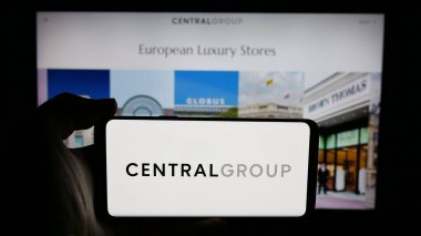 Stuttgart, Almanya - 05-03-2025: İnternet sayfasındaki ekranda Tayland şirketi Central Group logosunun bulunduğu cep telefonu sahibi kişi. Telefon ekranına odaklan.