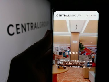 Stuttgart, Almanya - 05-03-2025: Tayland şirketi Central Group 'un web sitesi ile logo önünde akıllı telefon tutan kişi. Telefon ekranının merkezine odaklan.