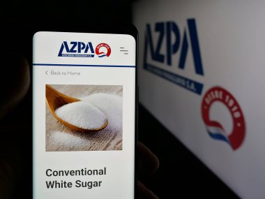 Stuttgart, Almanya - 05-03-2025: Logonun önünde Azucarera Paraguaya S.A. (AZPA) şirketinin web sitesi bulunan kişi. Telefon ekranının merkezine odaklan.