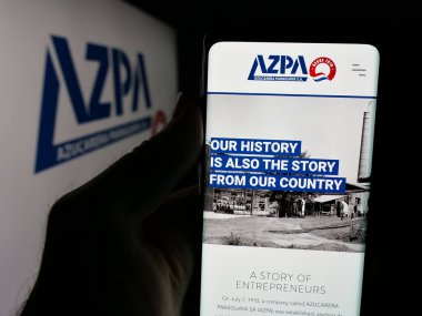 Stuttgart, Almanya - 05-03-2025: Logonun önünde Azucarera Paraguaya S.A. (AZPA) şirketinin web sayfası bulunan kişi. Telefon ekranının merkezine odaklan.