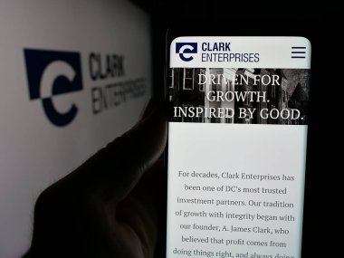 Stuttgart, Almanya - 05-03-2025: ABD 'li yatırım şirketi Clark Enterprises Inc.' in web sitesi ile akıllı telefon sahibi kişi logo önünde ekranda. Telefon ekranının merkezine odaklan.