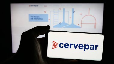 Stuttgart, Almanya - 05-03-2025: İnternet sayfasının önünde Cerveceria Paraguaya S.A. (Cervepar) şirketinin logosuna sahip cep telefonu sahibi kişi. Telefon ekranına odaklan.