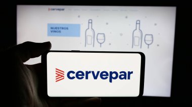 Stuttgart, Almanya - 05-03-2025: İnternet sayfası önünde Cerveceria Paraguaya S.A. (Cervepar) şirketinin logosunu elinde tutan kişi. Telefon ekranına odaklan.