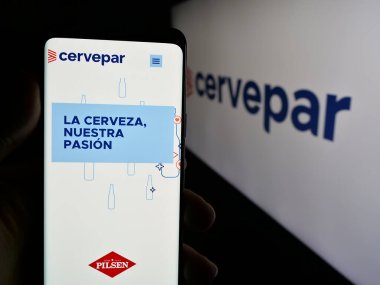 Stuttgart, Almanya - 05-03-2025: Logo önündeki ekranda Cerveceria Paraguaya S.A. (Cervepar) şirketinin web sayfası olan cep telefonu sahibi kişi. Telefon ekranının merkezine odaklan.