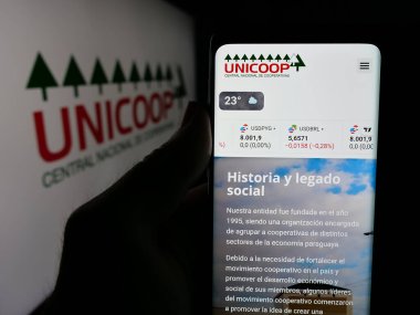Stuttgart, Almanya - 05-04-2025: Logo önünde Union Agricola de Cooperativas (UNICOP) web sitesi bulunan kişi. Telefon ekranının merkezine odaklan.