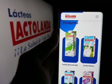 Stuttgart, Almanya - 05-04-2025: Paraguay mandıra şirketi Lactolanda 'nın web sitesi ile akıllı telefon sahibi kişi logonun önünde ekranda. Telefon ekranının merkezine odaklan.