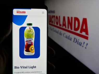 Stuttgart, Almanya - 05-04-2025: Paraguay mandıra şirketi Lactolanda 'nın internet sayfası ile cep telefonu tutan kişi logonun önünde ekranda. Telefon ekranının merkezine odaklan.
