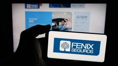 Stuttgart, Almanya - 05-04-2025: Paraguaylı sigorta şirketi Fenix Seguros 'un logosunun bulunduğu cep telefonu web sayfasının önünde duruyor. Telefon ekranına odaklan.