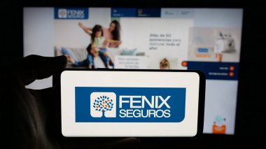 Stuttgart, Almanya - 05-04-2025: Paraguay sigorta şirketi Fenix Seguros 'un logosunun bulunduğu cep telefonu web sayfası önünde ekranda. Telefon ekranına odaklan.