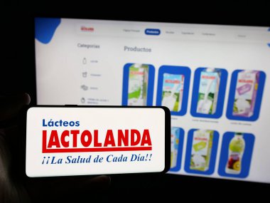 Stuttgart, Almanya - 05-04-2025: Paraguay mandıra şirketi Lactolanda 'nın logosunu elinde tutan kişi web sitesinin önünde ekranda. Telefon ekranına odaklan.