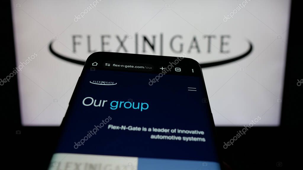 Stuttgart, Germany - 05-02-2025: Mobile phone with webpage of US automotive company Flex-N-Gate LLC on screen in front of logo. Focus on top-left of phone display.