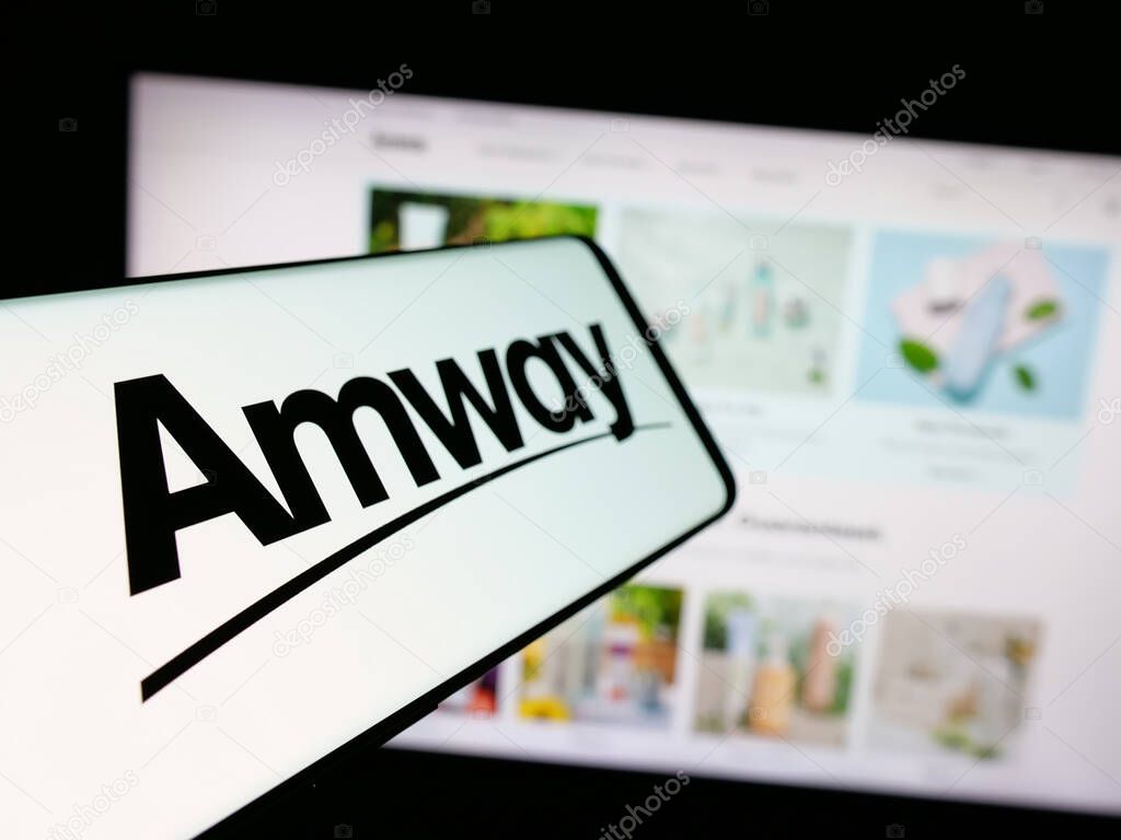 Stuttgart, Germany - 05-02-2025: Smartphone with logo of US multi-level marketing company Amway Corp. on screen in front of website. Focus on center-left of phone display.
