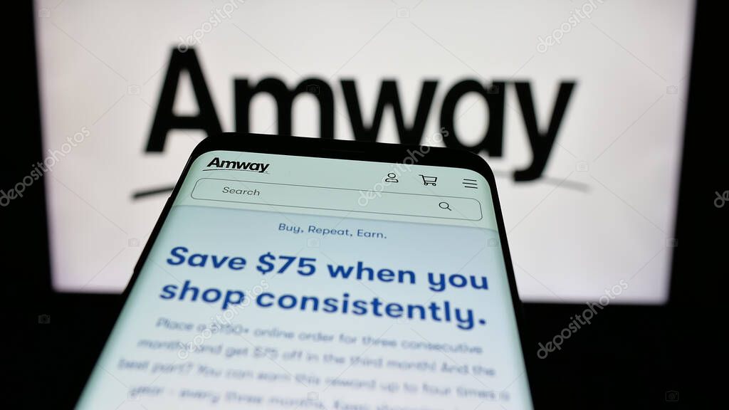 Stuttgart, Germany - 05-02-2025: Mobile phone with webpage of US multi-level marketing company Amway Corp. on screen in front of logo. Focus on top-left of phone display.